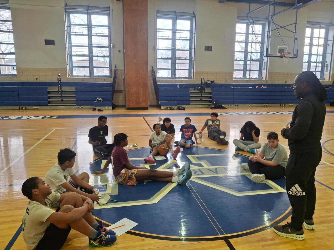A Canvas Institute facilitator speaks with a small group of students in a school conference room.